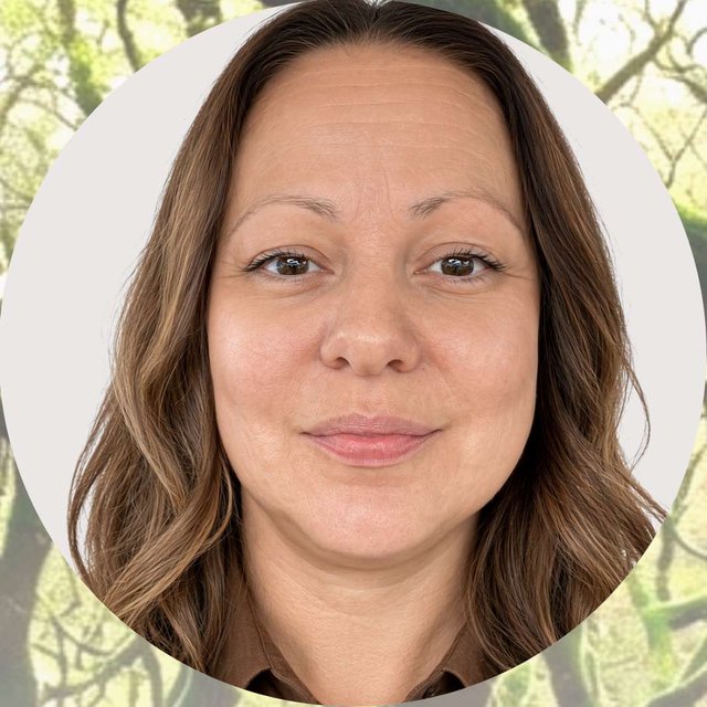 Nicola, SEND tutor, smiling in a woodland setting